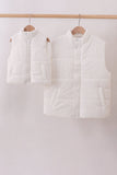 Two white puffer vests hanging on wooden hangers against a white background